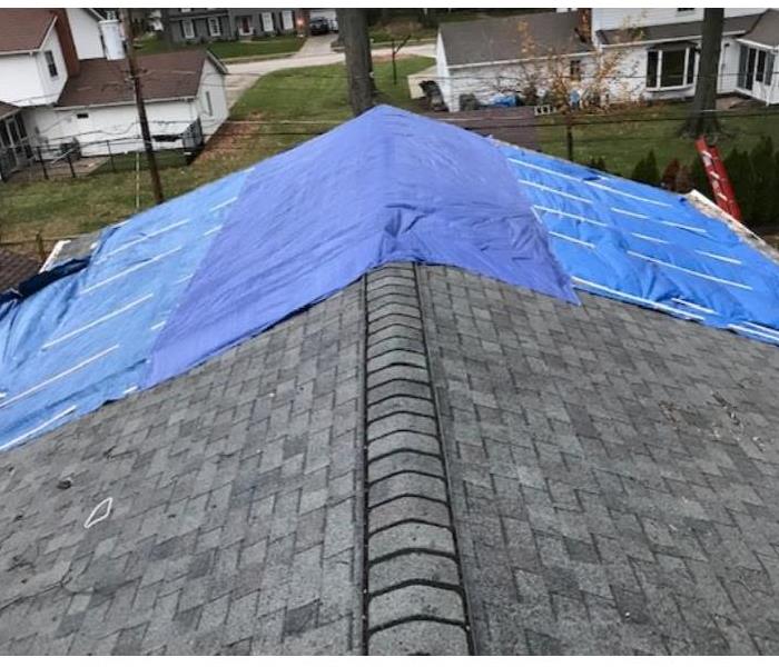 blue tarp on roof after storm damage 