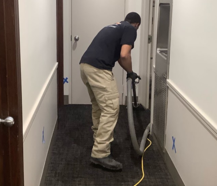male employee extracting water from carpet